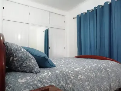 a bedroom with a bed with blue curtains at Burgau125 - villa near the beach in Vila do Bispo
