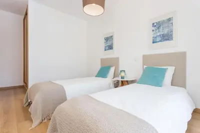 two beds in a room with white and blue at Villa Nooma in Carrapateira