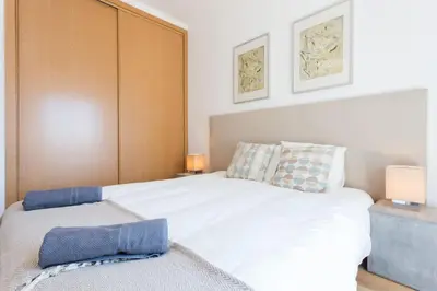a bedroom with a large white bed with two lamps at Villa Nooma in Carrapateira