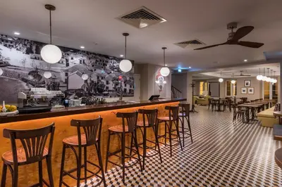a bar with a row of stools in a restaurant at Pestana Churchill Bay in Câmara de Lobos