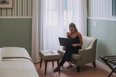 a woman sitting in a chair with a laptop at Pestana Churchill Bay in Câmara de Lobos