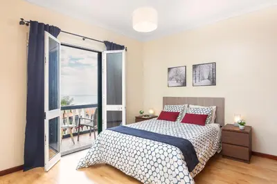 a bedroom with a bed and a large window at Villa Vista Mar in Funchal