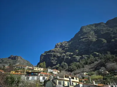 a village in front of a mountain at Valley of Nuns Holiday Apartments in Curral das Freiras