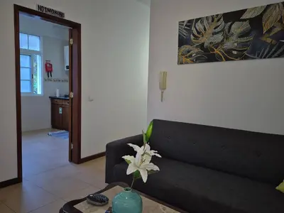 a living room with a couch and a table with a flower at Valley of Nuns Holiday Apartments in Curral das Freiras