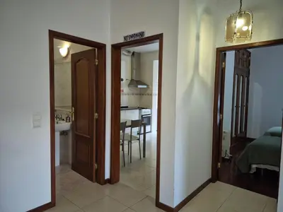 a hallway with a door open to a room with a table at Valley of Nuns Holiday Apartments in Curral das Freiras