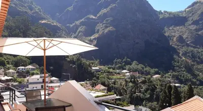 a patio with an umbrella and a view of a valley at Valley of Nuns Holiday Apartments in Curral das Freiras