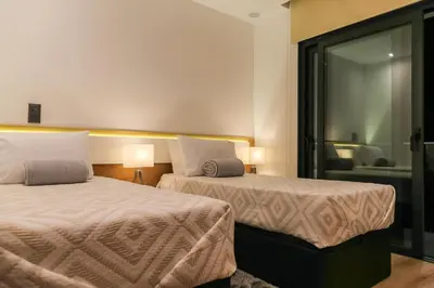 a hotel room with two beds and a chair at A&M House II Luxury Holidays Home in Arco da Calheta
