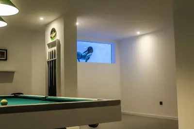 a room with a pool table and a screen at A&M House II Luxury Holidays Home in Arco da Calheta