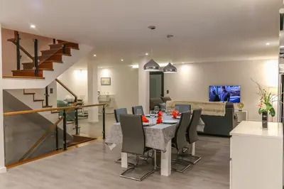 a dining room and living room with a table and chairs at A&M House II Luxury Holidays Home in Arco da Calheta