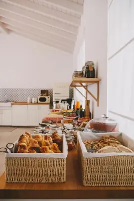 two baskets of pastries on a table in a kitchen at Pure Fonte Velha B&B in Vila do Bispo