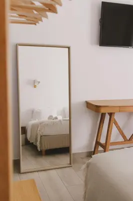 a mirror in a bedroom with a bed and a desk at Pure Fonte Velha B&B in Vila do Bispo
