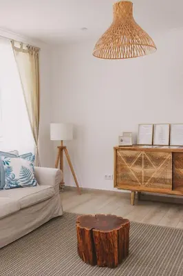 a living room with a couch and a table with a tree stump at Pure Fonte Velha B&B in Vila do Bispo
