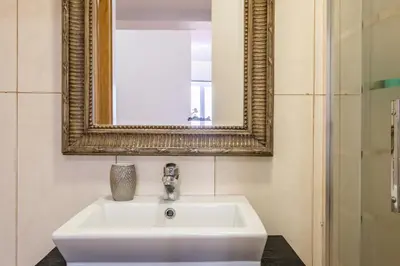 a white sink in a bathroom with a mirror at Cayres Suites Carmo in Funchal