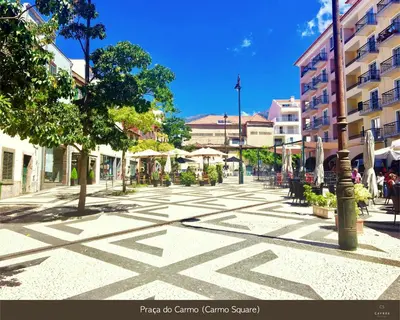 a city street with tables and chairs and buildings at Cayres Suites Carmo in Funchal