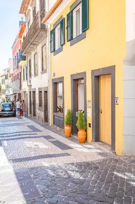 a cobblestone street in a city with buildings at Cayres Suites Carmo in Funchal
