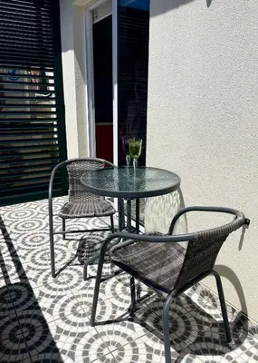 a glass table and two chairs on a patio at Apartamento Burgo 