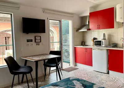 a kitchen with red cabinets and a table and chairs at Apartamento Burgo 