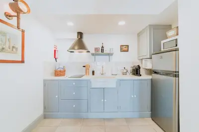 a kitchen with blue cabinets and a sink and a refrigerator at Casa da Praia in Câmara de Lobos