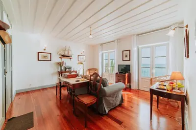 a living room with a table and a dining room at Casa da Praia in Câmara de Lobos