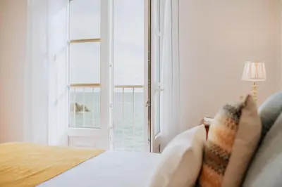 a bedroom with a bed and a large window at Casa da Praia in Câmara de Lobos