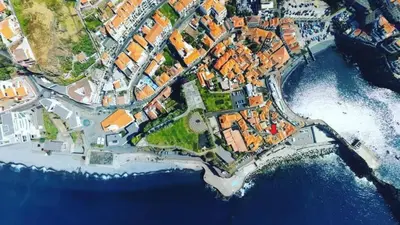 an aerial view of a city next to the water at Casa da Praia in Câmara de Lobos