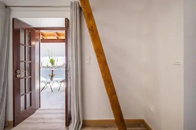 a hallway leading to a dining room with a mirror at Recanto Jardim Do Mar in Jardim do Mar