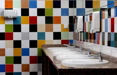 a row of sinks in a bathroom with a colorful wall at Sagres Sun Stay - Surf Camp & Hostel in Sagres