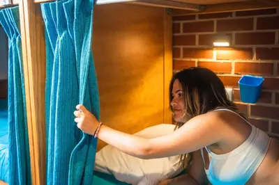 a woman is looking out of a window at Sagres Sun Stay - Surf Camp & Hostel in Sagres