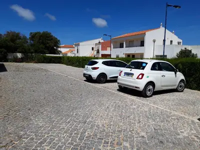 a person standing on a beach with a boat in the ocean at Sea Sagres in Sagres