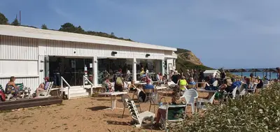 a crowd of people sitting in chairs outside of a building at Villa Cabanas beach in Budens