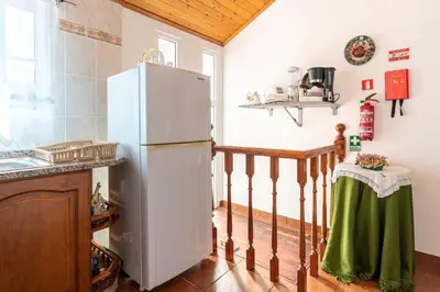 a kitchen with a white refrigerator in a room at Apartamento Isabel in Achada de Cima