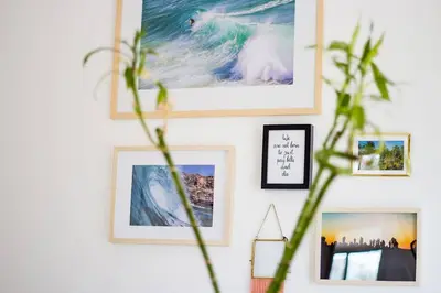 a wall with pictures and a plant on it at Casa Mawi in Sagres