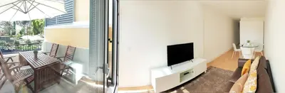 a living room with a television and a balcony at Superior Rentals - Downtown Villa in Funchal