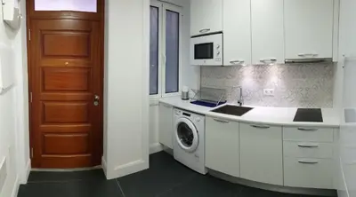 a white kitchen with a washing machine and a door at Superior Rentals - Downtown Villa in Funchal