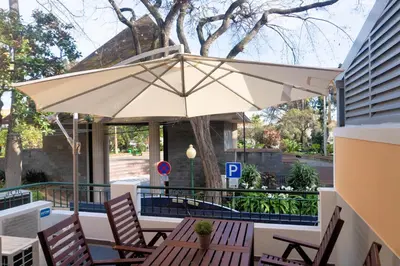 a table and chairs with an umbrella on a patio at Superior Rentals - Downtown Villa in Funchal