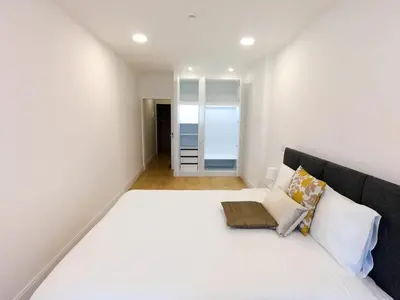 a bedroom with a large white bed and a mirror at Superior Rentals - Downtown Villa in Funchal