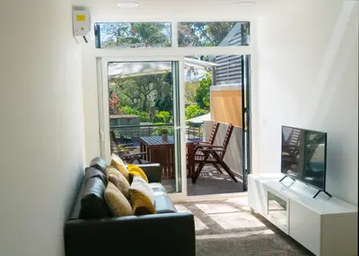 a living room with a couch and a sliding glass door at Superior Rentals - Downtown Villa in Funchal