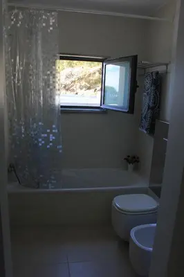 a bathroom with a tub and a toilet and a window at Sea House Madeira in Garajau