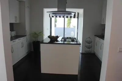 a kitchen with a white counter and a window at Sea House Madeira in Garajau