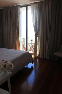 a bedroom with a bed and a large window at Sea House Madeira in Garajau