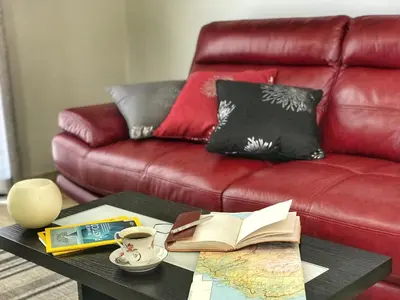 a coffee table with books and a red couch at Lucilia's House in Calheta