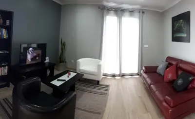 a living room with a red couch and a tv at Lucilia's House in Calheta