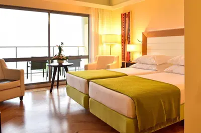 a hotel room with a bed and a balcony at Pestana Promenade Ocean Resort Hotel in Funchal