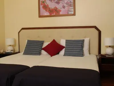 a bedroom with two beds with blue and red pillows at Casa dos Serrões in Calheta