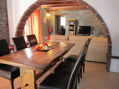 a dining room with a wooden table and chairs at Casa dos Serrões in Calheta