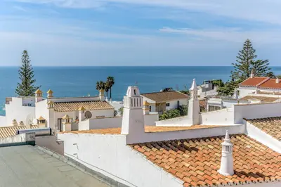 a view of the roofs of a town with the ocean at FLH Praia da Luz Apartment with Balcony in Luz