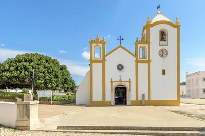 a church with a clock on the front of it at FLH Praia da Luz Apartment with Balcony in Luz
