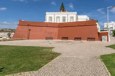 a building with two benches in front of it at FLH Praia da Luz Apartment with Balcony in Luz