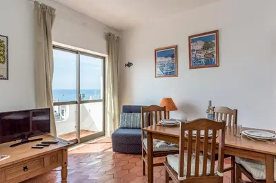 a living room with a dining table and a television at FLH Praia da Luz Apartment with Balcony in Luz