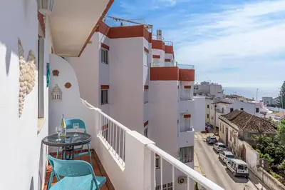 a balcony with chairs and a view of a street at FLH Praia da Luz Apartment with Balcony in Luz